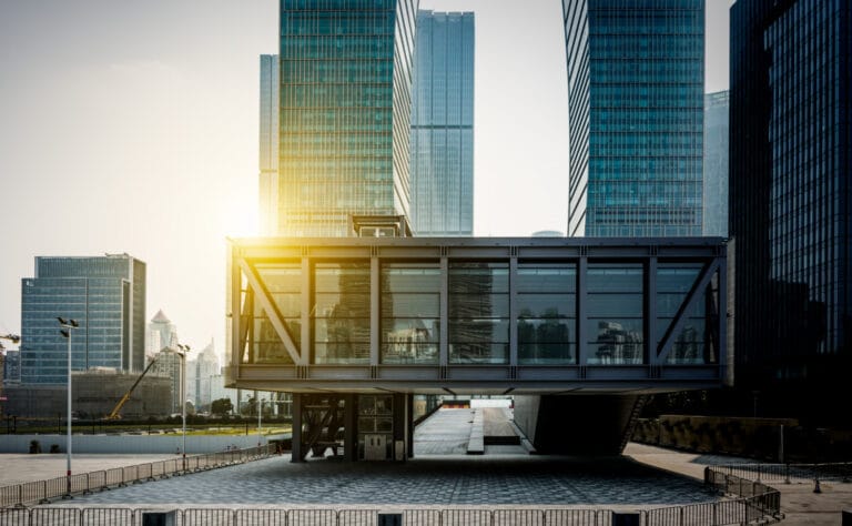 A modern commercial building among glass office towers at sunrise